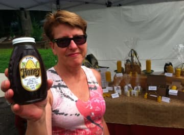 Beekeeper Patty Heyl, of Redding, holds up a bottle of honey at the Wilton sidewalk sale.