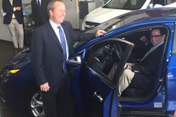 Leo Karl III of Karl Chevrolet in New Canaan (standing) and State DEEP Commissioner Robert Klee (sitting) check out a 2016 Chevrolet Volt while promoting a new state rebate program encouraging drivers to buy electric and hybrid vehicles.