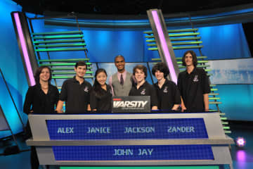 The John Jay students competing on The Challenge are, Alex Lee, Janice Choi  (alternate), Jackson Ruzzo (captain), Alexander Bolgar, and Angelo Angelino. At left is academic adviser Vicky Weiss and at center is "The Challenge" host Jared Cotter.