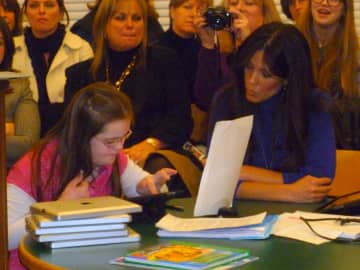 Increase Miller Elementary School student Kaycie Rooney, left, with the help of her teacher Allison Emig, demonstrates to the Katonah-Lewisboro school board how the iPad has helped increase learning in the special education classroom.