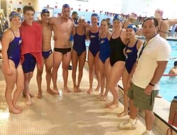 Omar Cruz, right, stands with swimmers from the ZEUS team in Norwalk at one of his final meets. Cruz stepped down after 14 years with the team to devote more time to his real estate business.