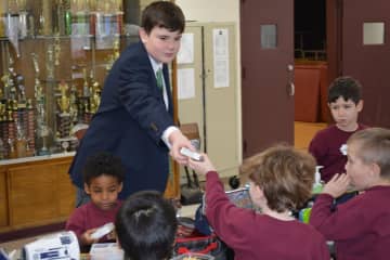 8th Grader Connor Breen of Scarsdale handed out ice cream treats as part of his duties while taking part in “Principal for a Day” at Iona Prep.