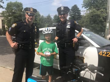 Officer Lent and Sergeant Dispenza of the Larchmont Police Department with 8-year-old Gavin Lee of Larchmont.