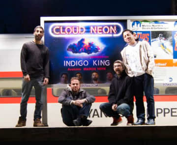 Indigo King poses in front of their billboard at the Ossining Train Station