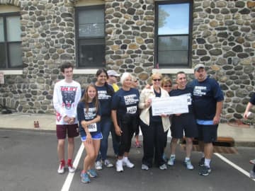 The Eastchester Irish American Social Club (EIASC) presents a ceremonial check for $15,000 to the Friends of the Eastchester Library from the proceeds of the Second Annual Eastchester 5K Race on Sept. 27. 2015.