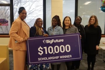 Mount Vernon high school junior Tamera Tate (third from left) receives a $10,000 scholarship from the College Board with school officials, her mother, and twin sister in attendance.